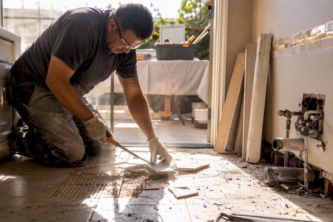 Contractor removing bathroom tile flooring