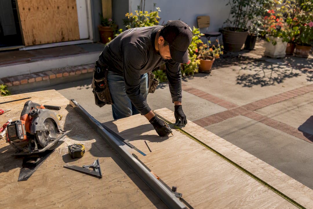 Technician cutting plywood for emergency board-up