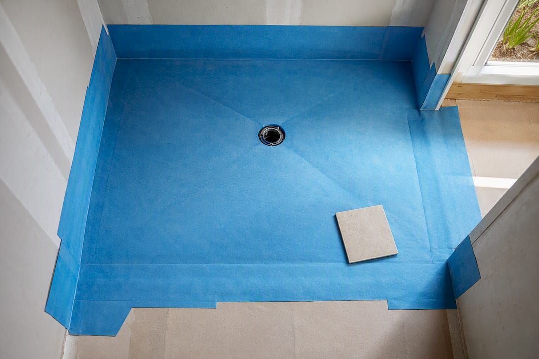 Waterproofing membrane across recessed shower floor
